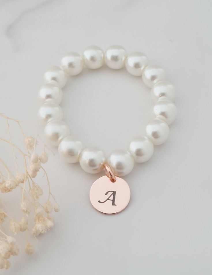 This sweet little pearl bracelet is personalised pearl to suit your bridal party. This bridal bracelet is made from 8mm glass pearls and 12mm rose gold plated initial disc. Your jewellery will arrive in a gift box ready for giving. This item ships from the UK within 1 working day. Please see size guide below: Sizes for children 3-6 months    4.25-4.5in 6-12 months    4.75in 12-24 months    5in 2-3 years    5.0-5.5in 4-5 years    5.75in 6-8 years    6in 9-13 years    6.25in Adult Sizes Small                  6.5in Medium             7in Large                  7.5in Adjustable Pearl Drop Bracelet For Bridesmaids, Personalized Beaded Wedding Bracelets, Adjustable Beaded Bracelets With Pearl Drop For Bridesmaid, White Pearl Drop Bracelets For Bridesmaids, White Pearl Drop Bracelet For Bridesmaids, Pearl Bracelet With Pearl Charm For Bridesmaids, Adjustable Pearl Charm Jewelry For Bridesmaid Gift, Pearl White Bracelets With Pearl Charm For Bridesmaids, Elegant Hypoallergenic Name Bracelet With Round Beads