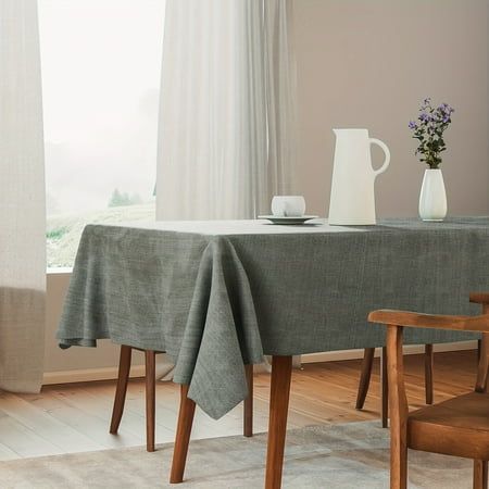 a dining room table with two chairs and a vase on the table next to it