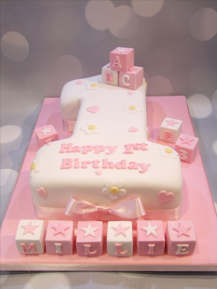 a pink and white birthday cake with blocks on it