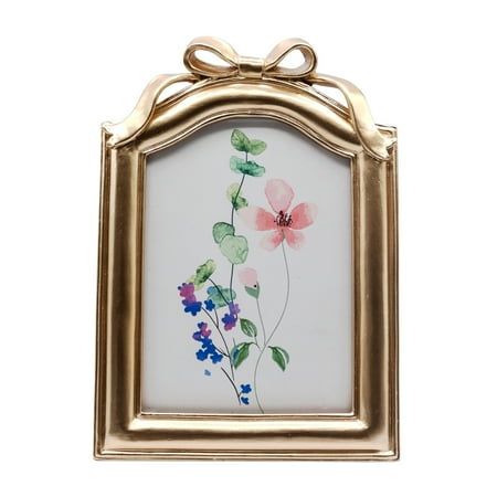 an ornate gold frame with flowers painted on the glass and hanging from it's sides