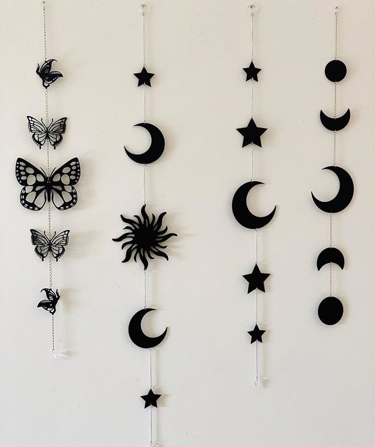 a group of black and white wall hangings with stars, moon and butterflies on them