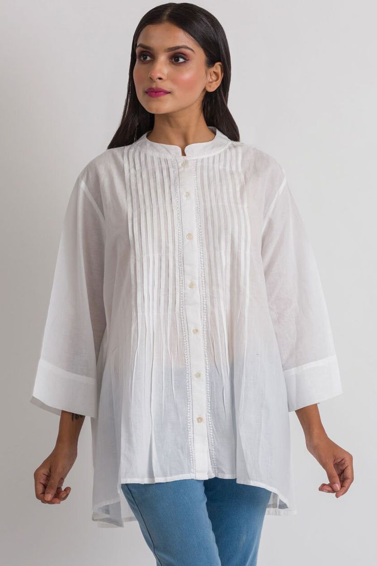 "Our Rajani Tunic is hand embroidered by women artisans in Northern India in the shadow-work style known as \"Chikankari\" on soft 100% cotton fabric. Chikankari is a delicate and artfully done hand embroidery technique that women in this region have been doing for generations. This elegant tunic features a Nehru collar, button down front with pleats, and exquisite hand embroidery on the back.  This style is free size, and is designed for a comfortable fit up to size XXL." Spring Handloom Chanderi Kurta, Traditional Festive Kurta With Pintucks, Festive Traditional Kurta With Pintucks, Traditional Straight Kurta With Pintucks, Traditional Pintucks Kurta, Cotton Tops With Pintucks And Relaxed Fit, Relaxed Fit Cotton Tops With Pintucks, Spring Cotton Kurta With Pintucks, Elegant Cotton Kurta With Cutdana