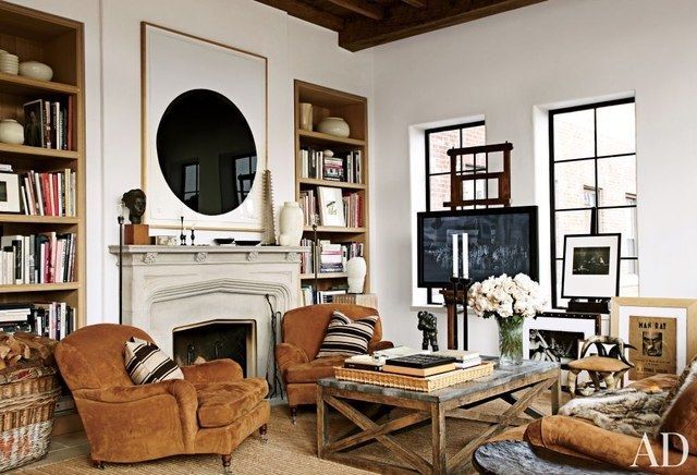 a living room filled with furniture and bookshelves next to a fire place in front of a fireplace