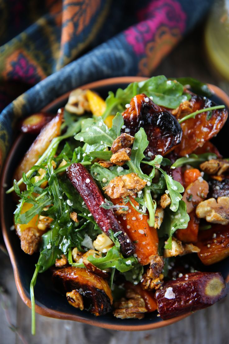 a salad with carrots, nuts and greens in a bowl