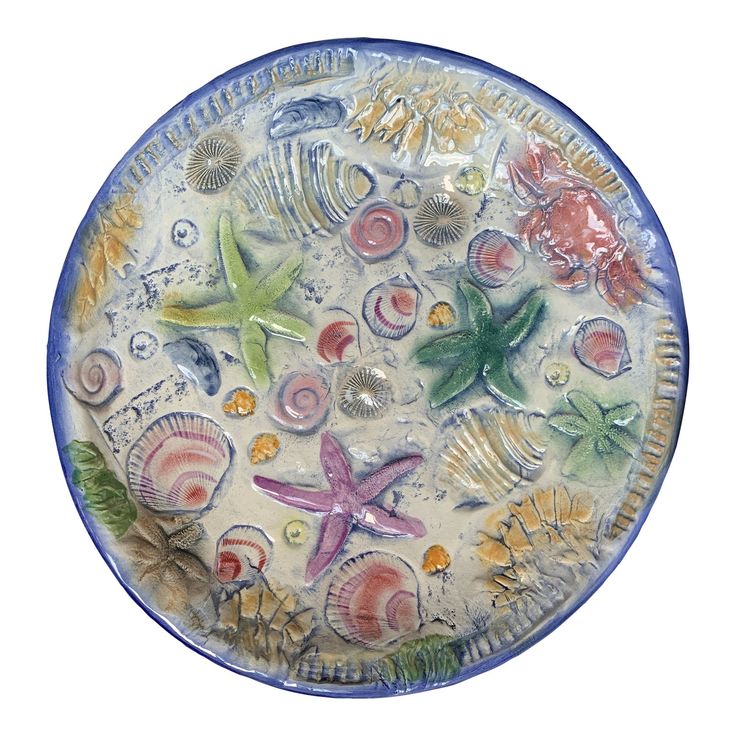 a blue and white plate with sea shells on the bottom is shown in full color