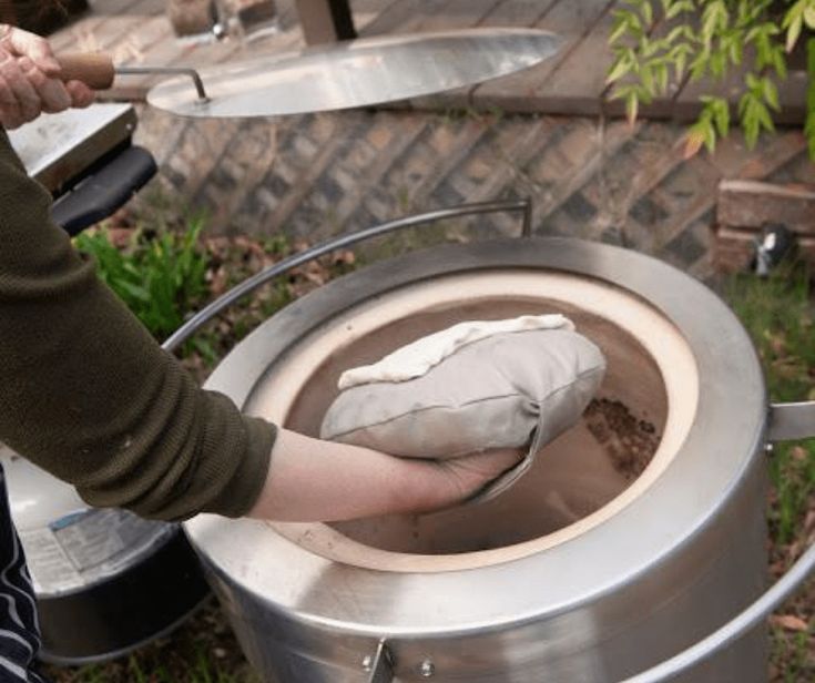 a person is holding something in a large pot