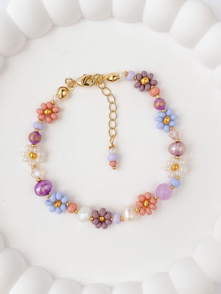 The Lila beaded bracelet is dainty and elegant. The perfect gift for any woman, friend, sister, daughter, etc. 100% handmade using the best materials.  FEATURES:  * Seed beads sizes 2 to 4mm, freshwater pearls 5-7mm, natural stones 4-6mm, crystals 4-6mm. * 18k Gold Plated Lobster clasp and findings. * Made with love and care. LENGHT: 6.5 inches + 1.5 inches extender chain CARE INSTRUCTIONS: *Remove before exercising taking a shower/bath and sleeping. *Avoid contact with moisture such as water, perfume, and other chemicals. *Store in a dry cool place. IMPORTANT: *Each piece is made to order and is individually handmade so there can be some differences from the picture, also the color can look a bit different in person than on the screen. Spring Flower Shaped Bracelet Gift, Daisy Flower Charm Bracelets As Gift, Flower Charm Bracelet With Round Beads, Daisy Flower Charm Bracelet For Gift, Round Beads Bracelet With Flower Charm As Gift, Adjustable Beaded Bracelets As Gift For Mom, Handmade Flower-shaped Pearl Bracelet As A Gift, Handmade Flower-shaped Pearl Bracelet Gift, Mother's Day Pearl Bracelet With Round Beads