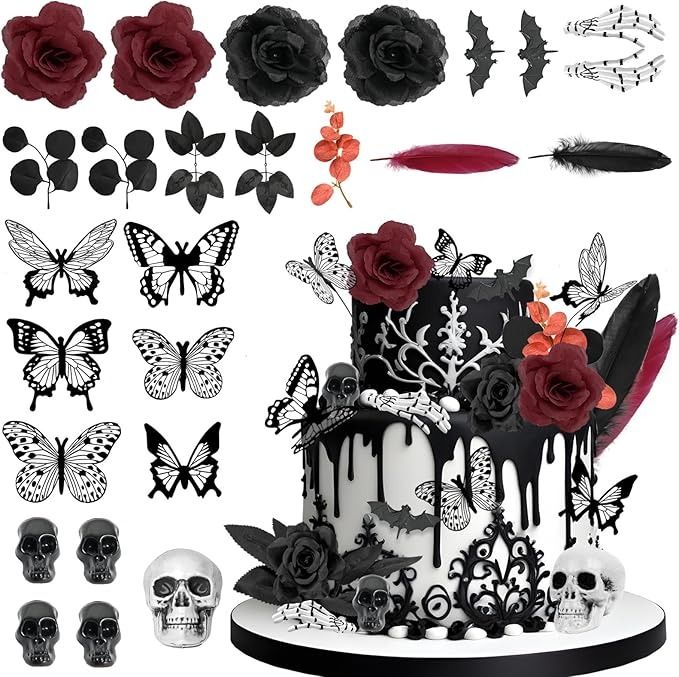 a cake decorated with black and white icing next to skulls, roses and feathers