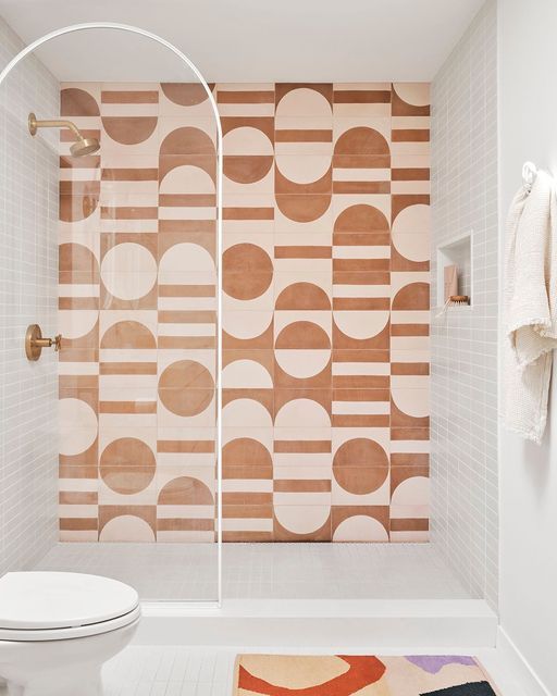 a white toilet sitting in a bathroom next to a wall with circles on it's side