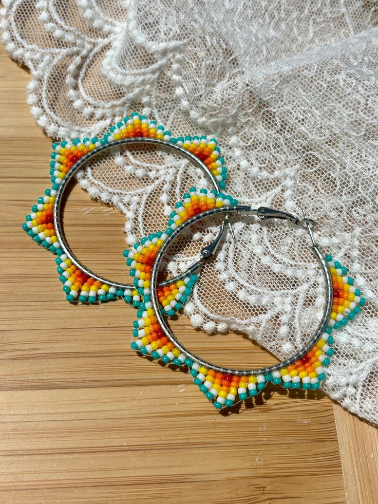 Hand beaded hoop earrings.  Hinge closure. Hoop measures approximately 2" wide. Hoop Seed Bead Earrings, Native Beaded Hoop Earrings, Native American Hoop Earrings, Adjustable Beaded Hoop Earrings, Adjustable Beaded Circle Earrings For Summer, Summer Hoop Beaded Earrings, Adjustable Small Beaded Hoop Earrings, Summer Festival Beaded Hoop Earrings, Small Beaded Hoop Earrings For Festivals