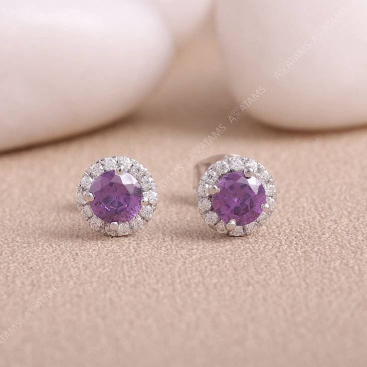 Amethyst Purple Stud Earring | Purple & White Moissanite Diamond Earring in 925 Sterling Silver | Gemstone Earring | Sapphire Stud Earrings These gorgeous gemstone earrings are a brilliant gift-giving choice for February birthdays and anniversaries. Ornate round-cut amethysts deliver standout style when sweetly embraced with bright round-cut white lab-created sapphires. Fashioned in stylish sterling silver. Earring Details: 1. No of Earrings - 1 Pair  2. Metal Color - Silver  3. Metal Type - 925 Fine Jewelry White Gold Birthstone Earrings, White Gold Birthstone Earrings Fine Jewelry, White Gold Diamond Earrings With Gemstones, White Gold Diamond Earrings With Round Cut Gemstone, White Gold Round Cut Diamond Earrings With Gemstone, Dazzling Sterling Silver Earrings With Halo Setting, Elegant Purple Gemstones With Halo Setting, Sterling Silver Round Earrings With Halo Setting, Diamond White Earrings With Halo Setting For Gift