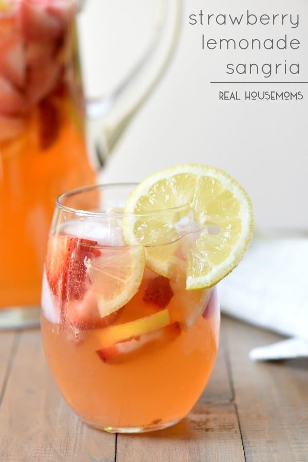 two glasses filled with water and fruit on top of a wooden table next to pitcher of lemonade