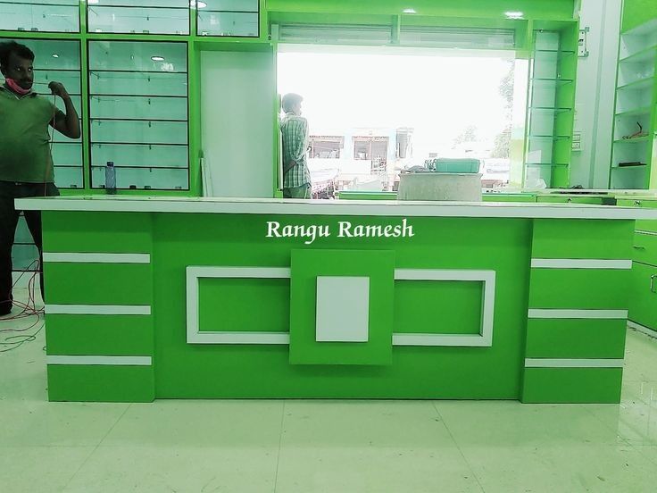 a man standing in front of a green counter with white trim on it and the words ranga rammesh written on it