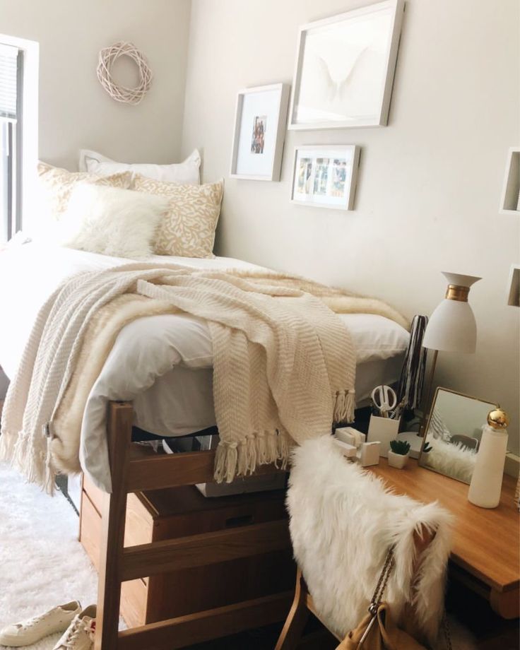 a bedroom with a bed, desk and pictures on the wall above it that are all white