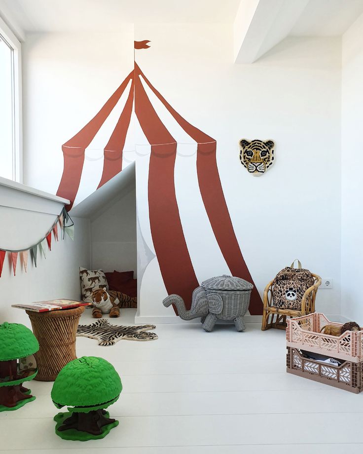 there are many stuffed animals and toys in this room with a tent on the wall