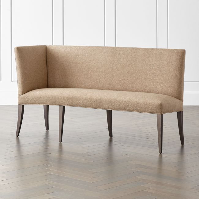 a beige bench sitting on top of a hard wood floor next to a white wall