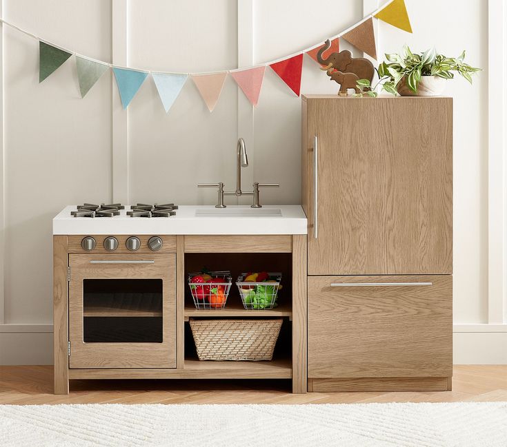 a kitchen area with a sink, stove and cupboards in front of bunting flags