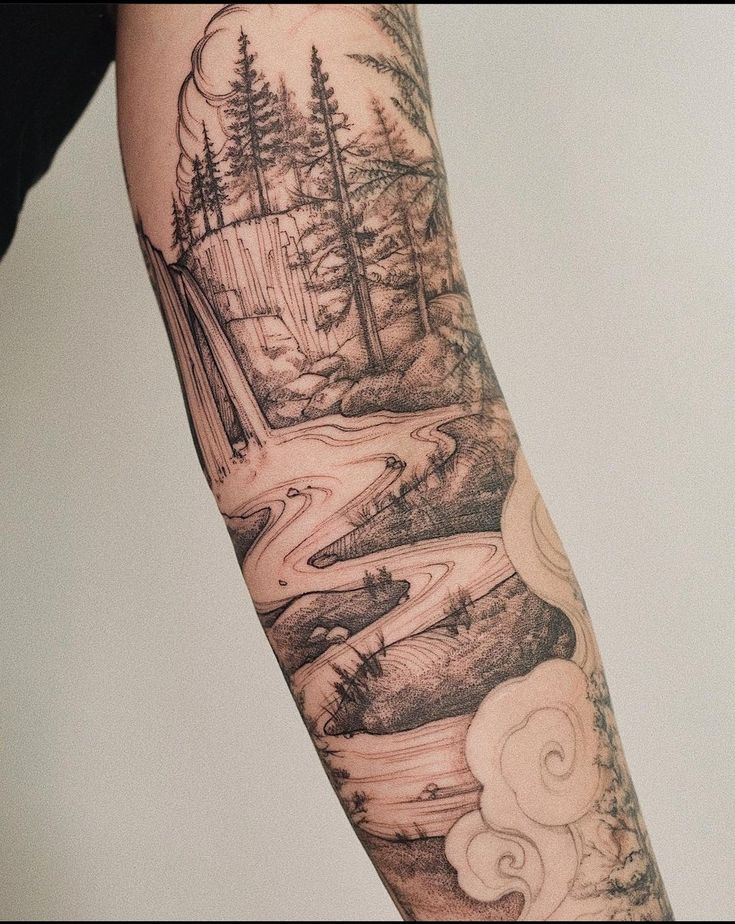 a man's arm with a river and trees tattoo on the left side of his arm