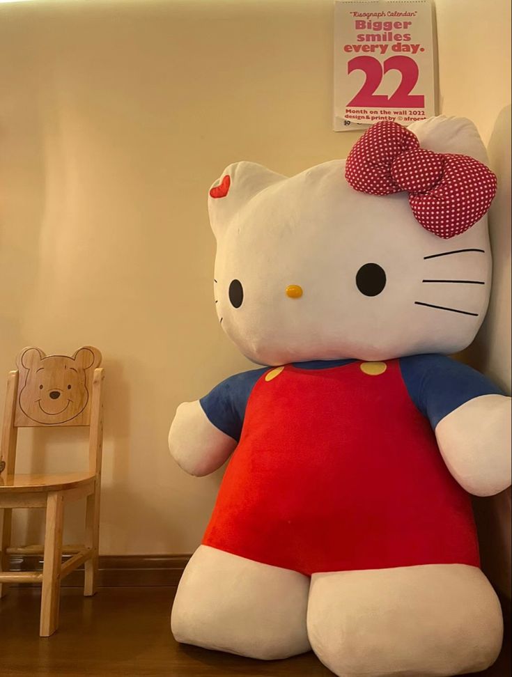 a large hello kitty stuffed animal sitting on top of a wooden floor