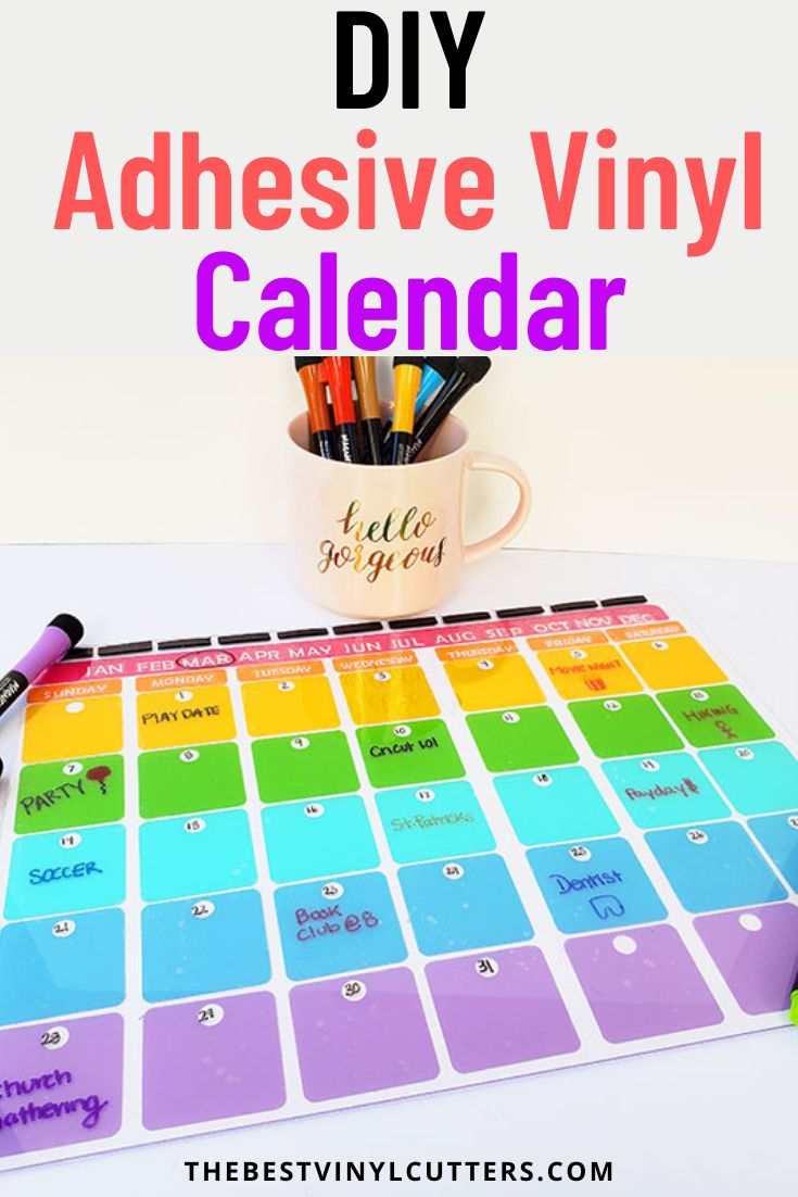 a colorful calendar with markers and pens on it, next to a coffee mug that says diy adhesive vinyl calendar