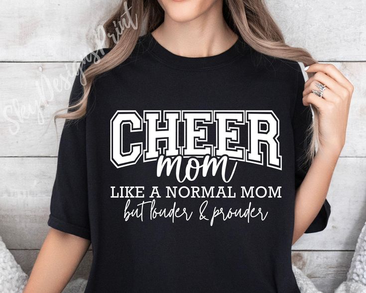 a woman wearing a cheer mom t - shirt with the words like a normal mom but harder and bigger