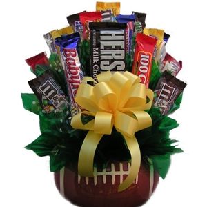 a basket filled with assorted chocolates and candy bar wrapped in yellow ribbon tied around it