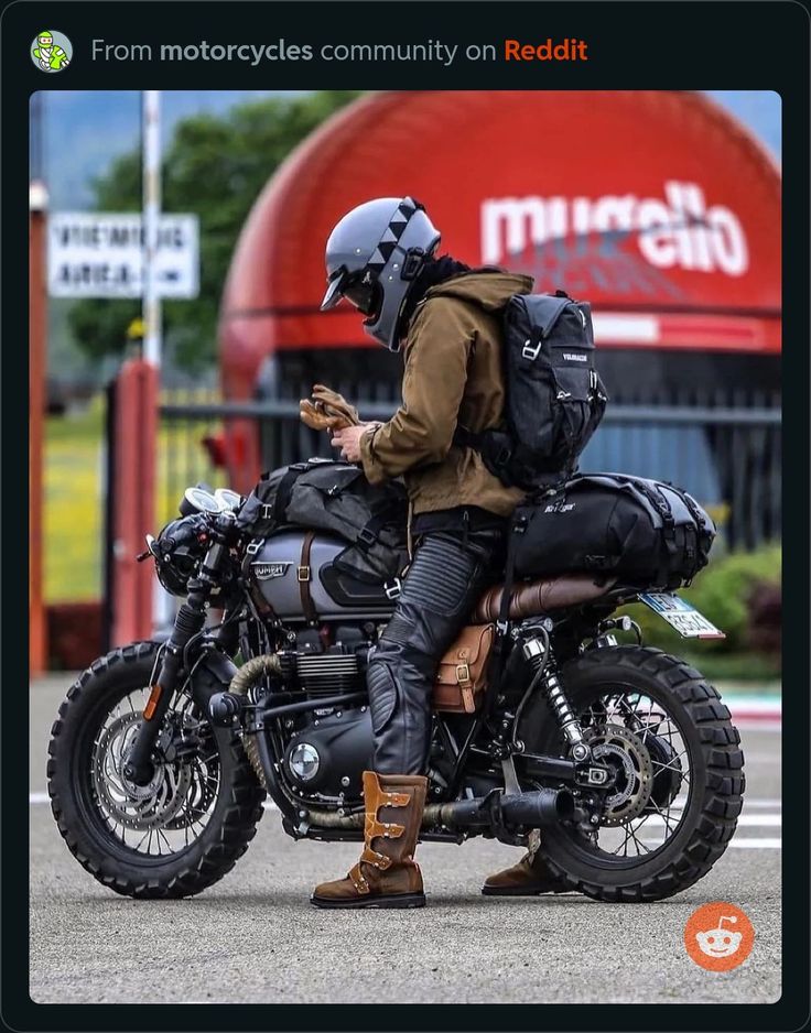 a man sitting on the back of a motorcycle while looking at his cell phone in front of a mcdonald's