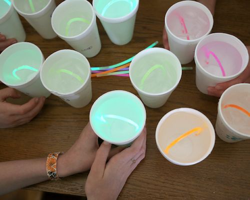 several people are sitting at a table with plastic cups and straws in front of them