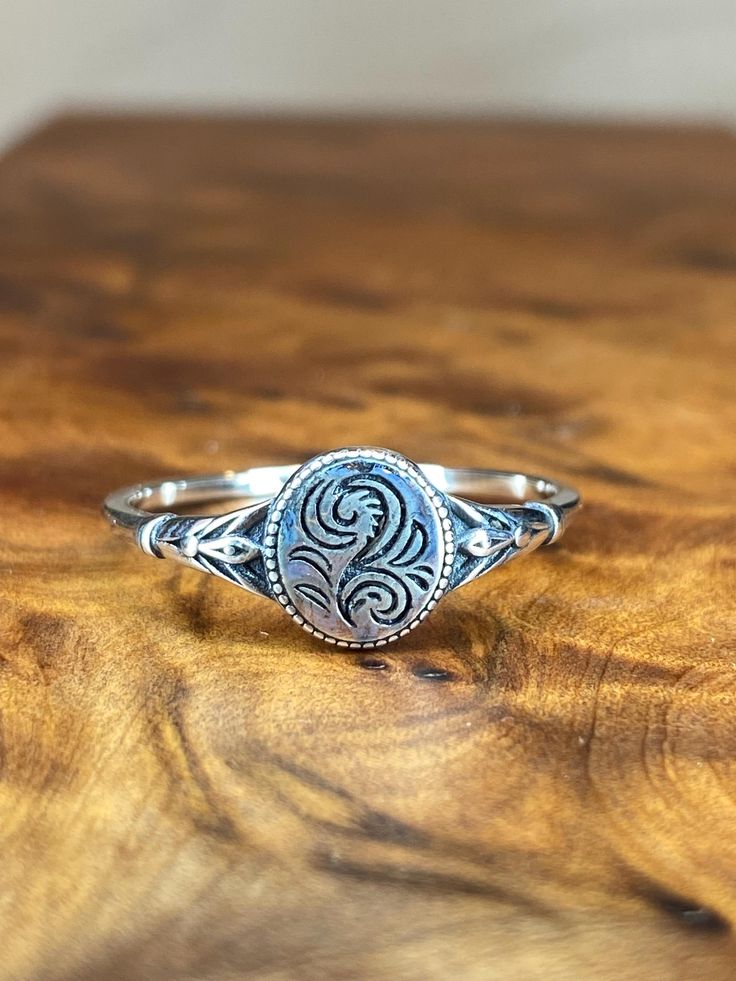 This sterling silver vintage style ring is a classic option for everyday wear. Works well with stackable styles as well. All of our rings are available in whole sizes only and are stamped with the .925 Hallmark, which is the international mark for sterling silver. .925 refers to the fact that sterling silver is an alloy, 92.5 parts silver to 100 parts metal. All of our jewelry is nickel free. Classic Oval Etched Rings, Classic Etched Oval Rings, Stackable Sterling Silver Dome Promise Ring, Stackable Sterling Silver Dome Ring For Promise, Oval Sterling Silver Engraved Ring, Silver Oval Etched Signet Ring, Oval Sterling Silver Etched Signet Ring, Etched Oval Sterling Silver Signet Ring, Antique Sterling Silver Engraved Open Ring