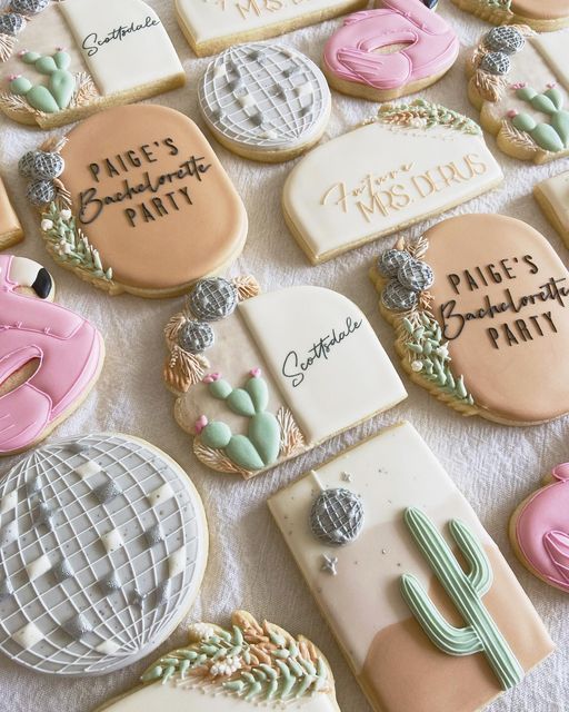 many decorated cookies on a table with writing and cactus decorations in the shape of letters