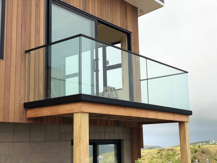 a wooden house with glass balconies on the balcony