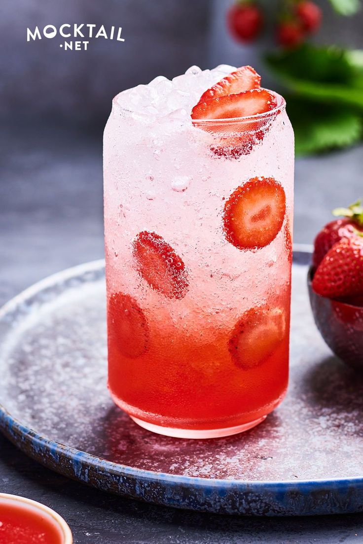 a drink with strawberries and ice on a plate