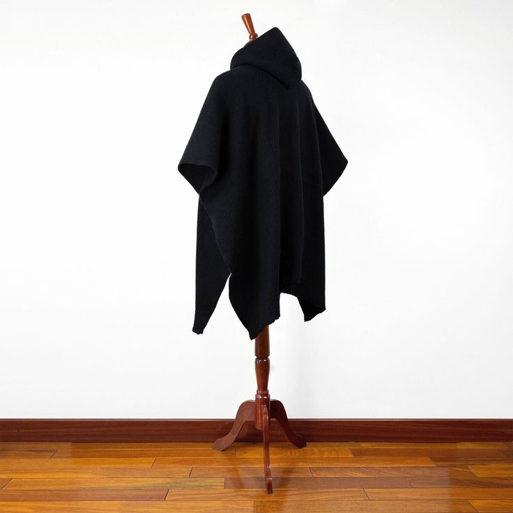 Stay warm and stylish this season with our Soft & Warm Llama Wool Hooded Poncho in Solid Black. This unisex poncho is crafted from high-quality llama wool yarn, providing a soft and comfortable feel that's perfect for chilly days. The fabric has been brushed for enhanced comfort, allowing you to snuggle up in warmth and style.The poncho features a classic hood that not only adds an element of style but also keeps your head and ears protected from the cold. The solid black color is versatile and One Size Winter Poncho, Winter Poncho In One Size, One Size Winter Poncho In Solid Color, Oversized Alpaca Poncho For Winter, Black Winter Cape For Outdoor, Black Winter Outdoor Cape, Black Alpaca Poncho For Winter, Black Hooded Poncho For Outdoor, Black Wool Cape Poncho