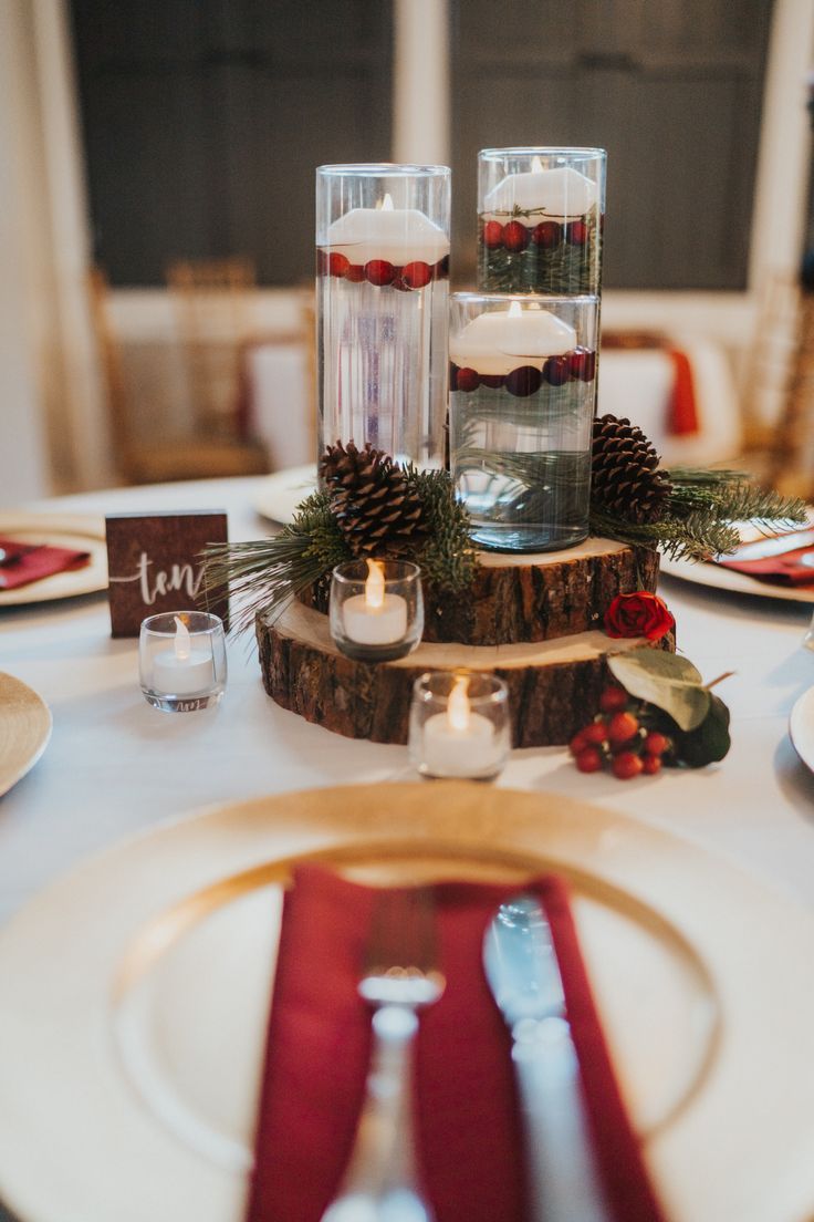 the table is set with pine cones and candles