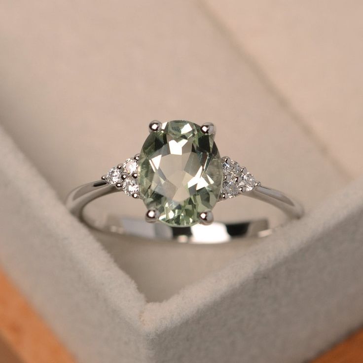 This ring features a 7*9mm oval cut natural green amethyst and sterling silver finished with rhodium. Customization is available. It is made by hand, and it will take about 7 days to finish the ring after your payment is completed. Main stone: Natural green amethyst Main stone weight: Approx 1.55 ct Metal type: sterling silver finished with rhodium/14k gold I can make it with 14k solid gold(rose/yellow/white) and diamond accent stone option, just feel free to contact me. Any question, just let m Light Green Engagement Ring, Green Amethyst Engagement Ring, Green Wedding Rings, Green Engagement Rings, Ring Green Stone, Green Stone Ring, Green Sapphire Ring, Green Gemstone Ring, Green Amethyst Ring