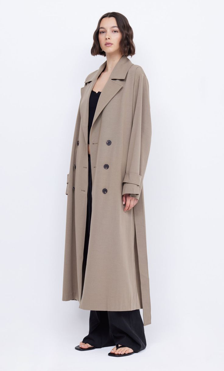 The BEC + BRIDGE Yvonne Trench coat is an oversized double breasted style cut from a wool blend. The coat features notch lapel details, relaxed drops shoulders, pockets, 6 button closure and a removeable waist tie. Oversized Wool Coat With Double-breasted Buttons, Chic Oversized Gabardine Outerwear, Modern Long Coat With Double-breasted Button, Oversized Long Coat With Hidden Button Closure, Modern Long Double-breasted Coat, Oversized Double-breasted Wool Coat, Spring Oversized Double-breasted Pea Coat, Oversized Wool Coat With Double Button And Lapel Collar, Oversized Notch Lapel Outerwear With Double Button Closure