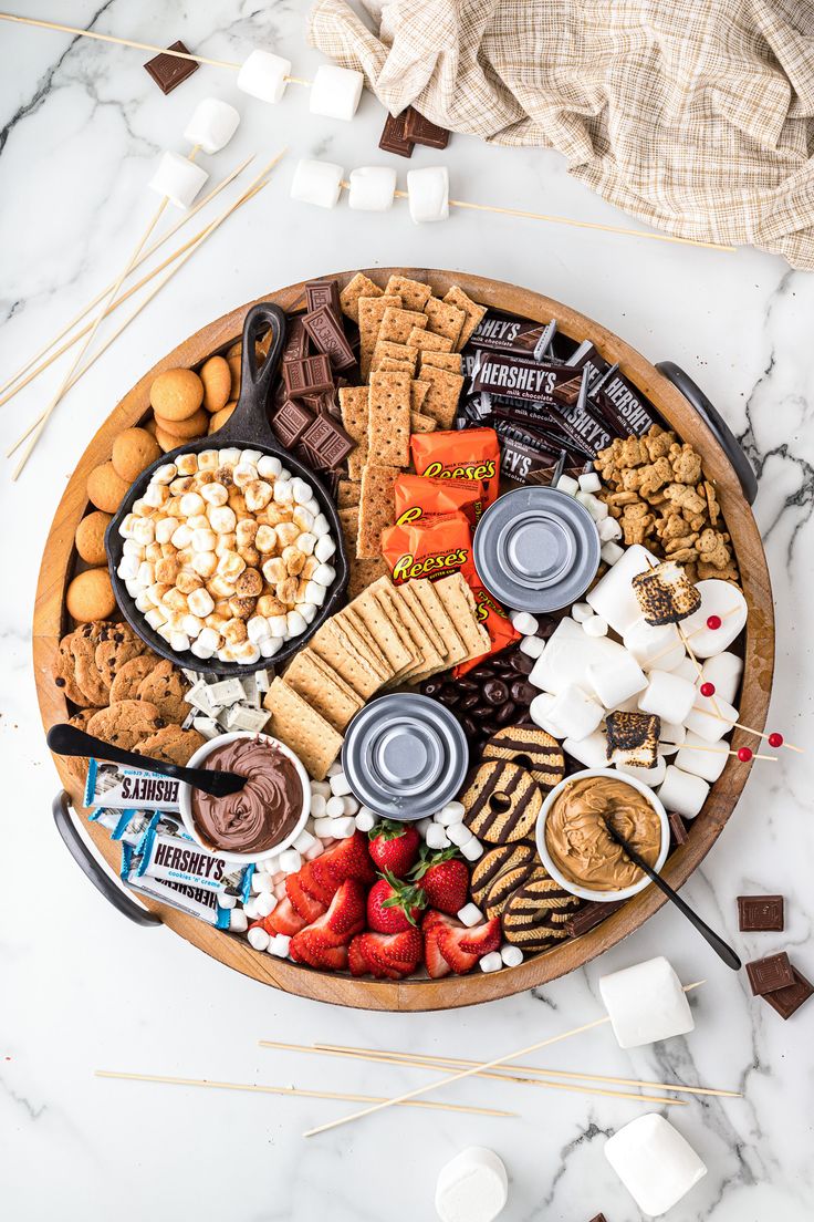 a wooden platter filled with snacks and desserts