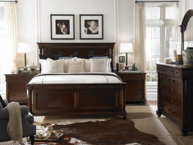 a bedroom with white walls and brown furniture