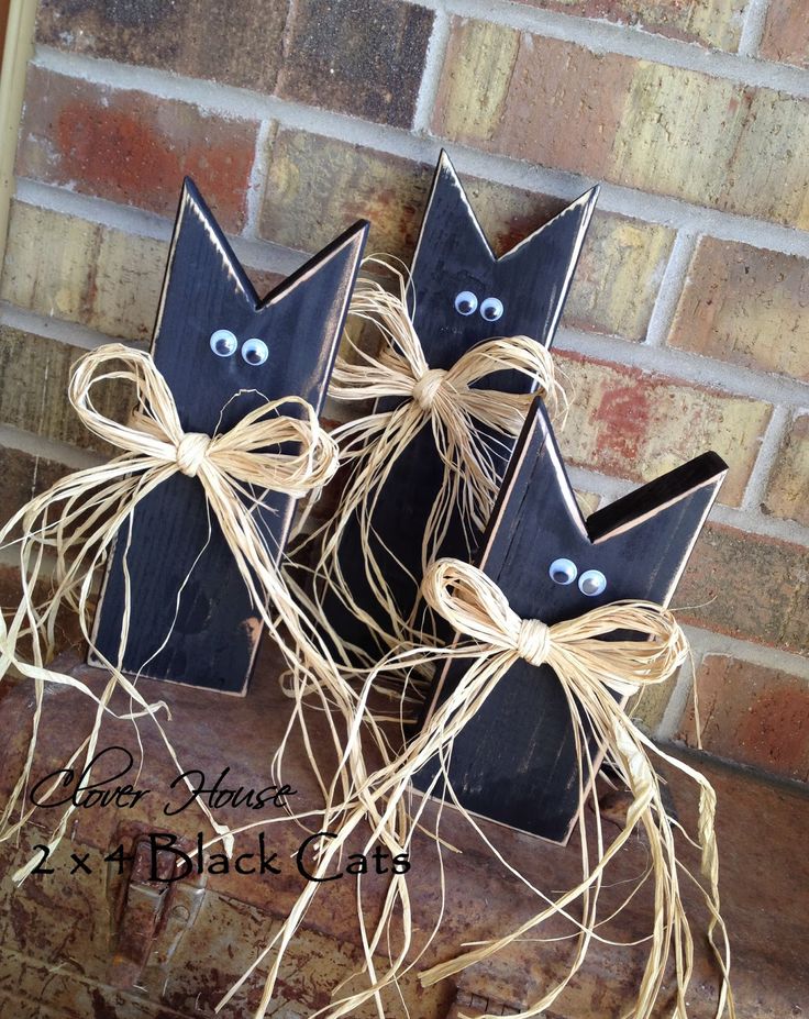 three black cats made out of wood sticks with eyes on them and tied up in twine