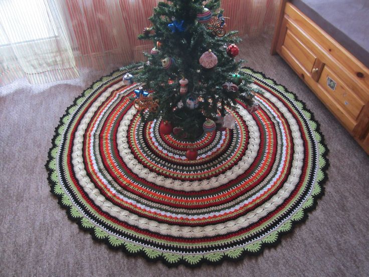 a christmas tree sits on top of a multicolored rug