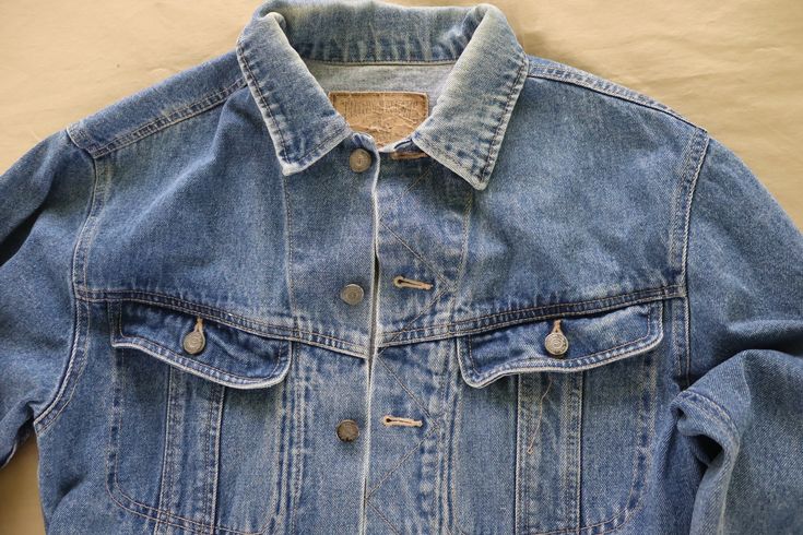 Medium wash denim jacket / trucker jacket with buttons and 4 front pockets. 100% cotton. Clean - freshly washed and lined dried. No stains or holes - in great shape.  Tag size is small.  Measures 20 inches laying flat from armpit to armpit (40 inches total);  23 inches long. The chest was measured laying flat, so the actual fit may vary somewhat. Measure a similar garment that fits you in the same manner for comparison.   Visit my shop for more vintage clothing, fabric, fabric panels, quilt blocks and quilt tops, vintage patterns, needlework and kits, original handmade creations and more - https://www.etsy.com/shop/VirgieMae Spring Grunge Button-up Denim Jacket, Grunge Cotton Denim Vest With Pockets, Classic Distressed Cotton Denim Jacket, Faded Denim Jacket For Streetwear With Button Closure, Faded Denim Jacket With Button Closure For Streetwear, 90s Style Washed Denim Jacket For Spring, Everyday Light Wash Distressed Denim Jacket, Faded Washed Button-up Denim Jacket, Faded Washed Denim Button-up Jacket