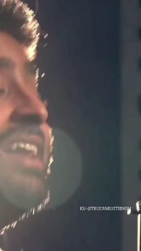 a man singing into a microphone with his mouth open