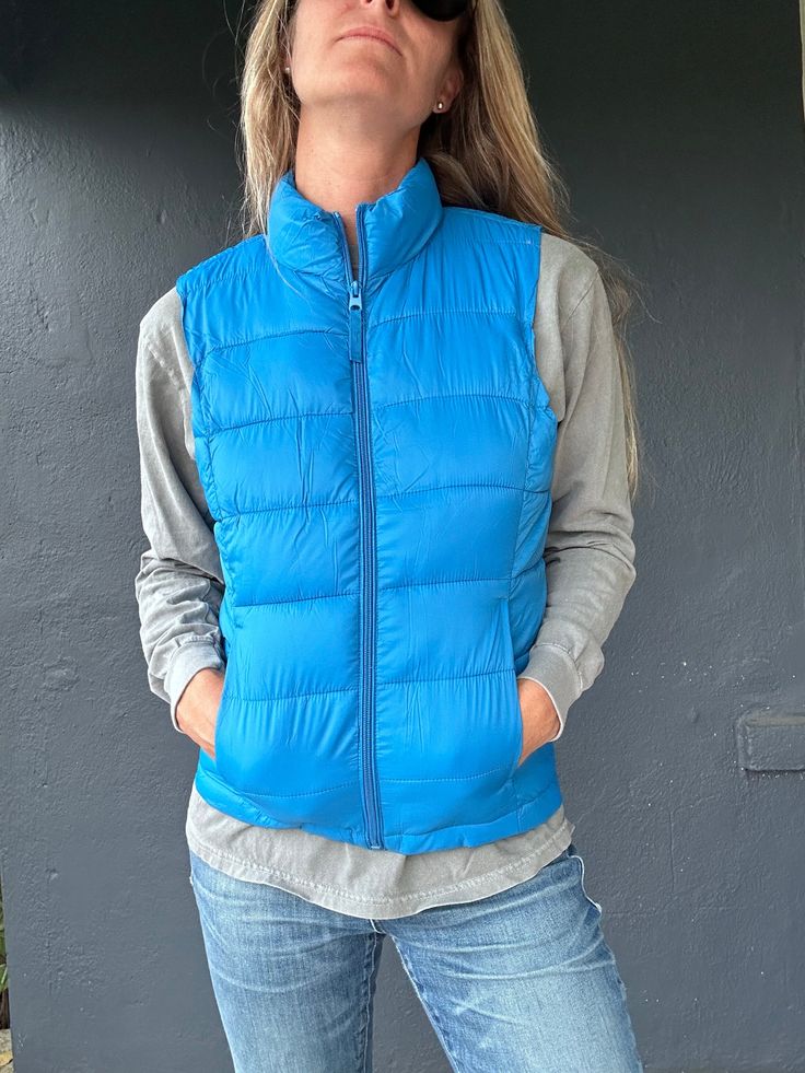 Stay toasty and on trend with the Beacon 2 Vest! This ultra-cozy puff vest has a high-neck design and a storage pouch for all your essentials. Keep warm and snug whether you’re out and about or just lounging around. Feeling fly has never been so easy! Casual Puffer Jacket For Travel, Casual Sleeveless Puffer Jacket With Pockets, Casual Sleeveless Puffer Jacket, Casual Solid Vest For Cold Weather, Blue Winter Vest For Outdoor Activities, Blue Vest For Outdoor Winter Activities, Winter Functional Solid Vest, Functional Solid Winter Vest, Functional Solid Color Winter Vest