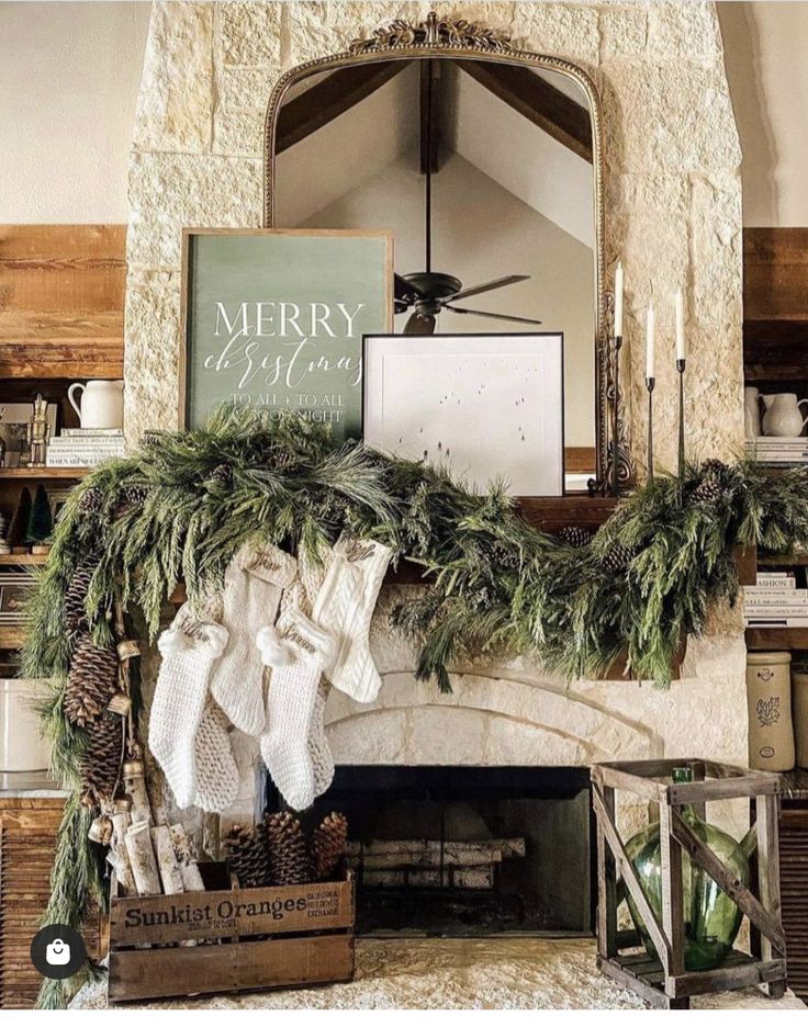 a mantel decorated with greenery and stockings