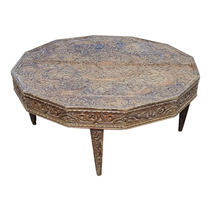 an ornately decorated coffee table with wooden legs