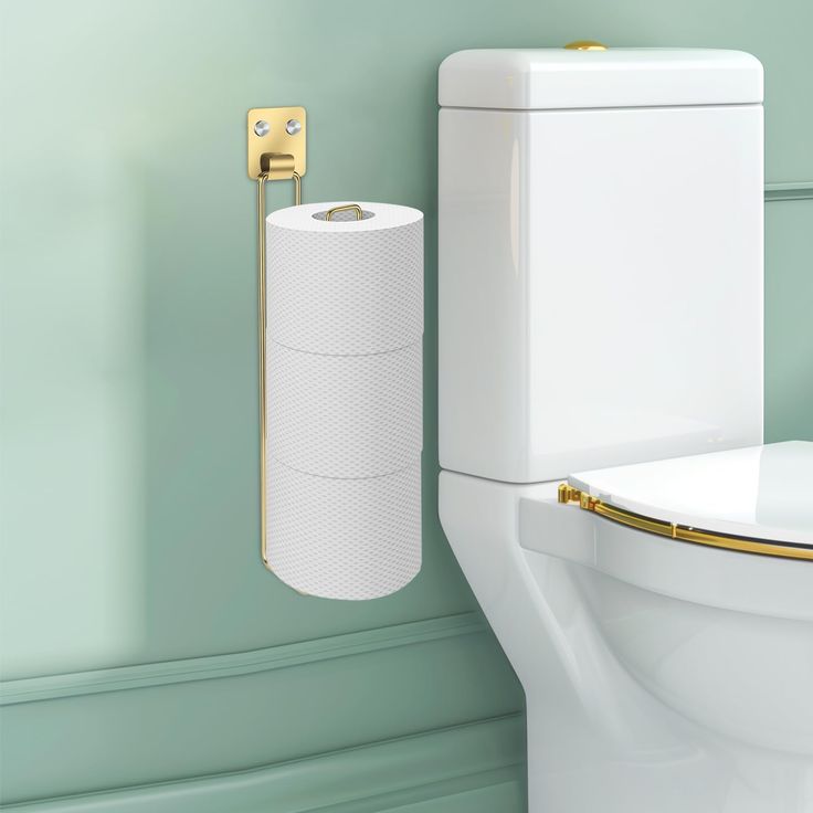 a white toilet sitting next to a wall mounted paper towel dispenser