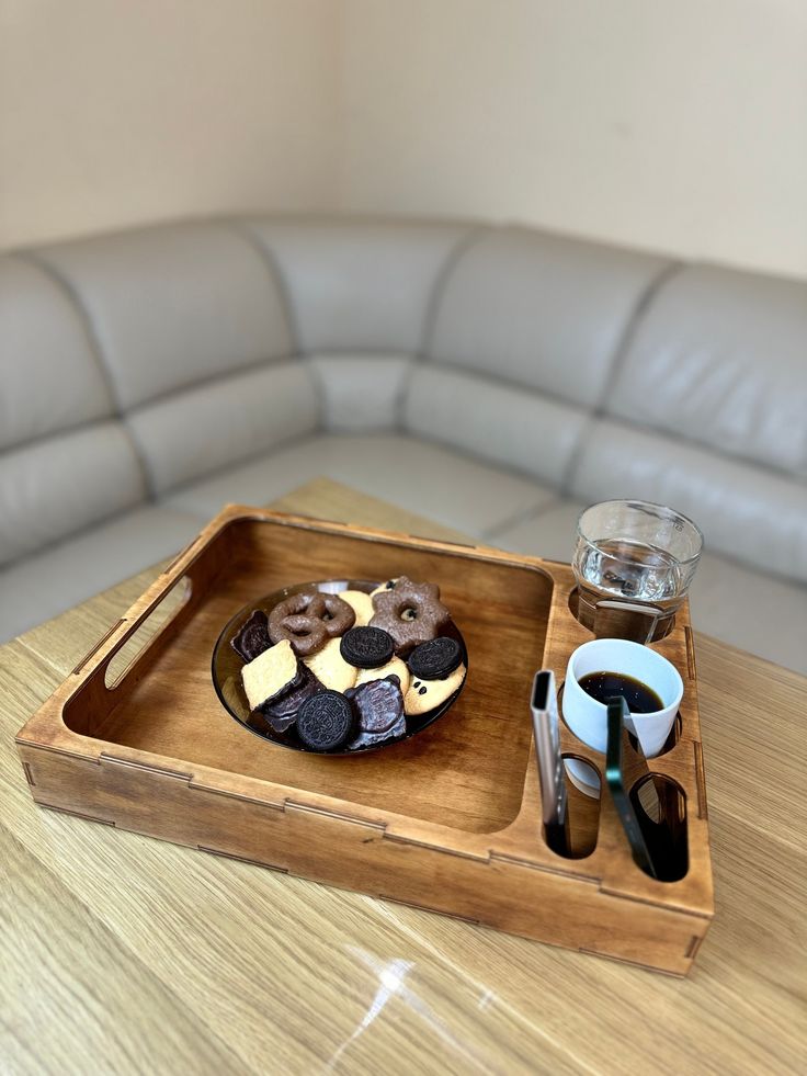 a tray that has some food in it on top of a table next to a couch