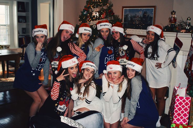 a group of women in christmas hats posing for a photo