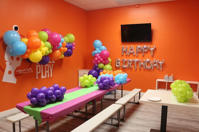 an orange room with balloons on the wall and a pink bench in front of it