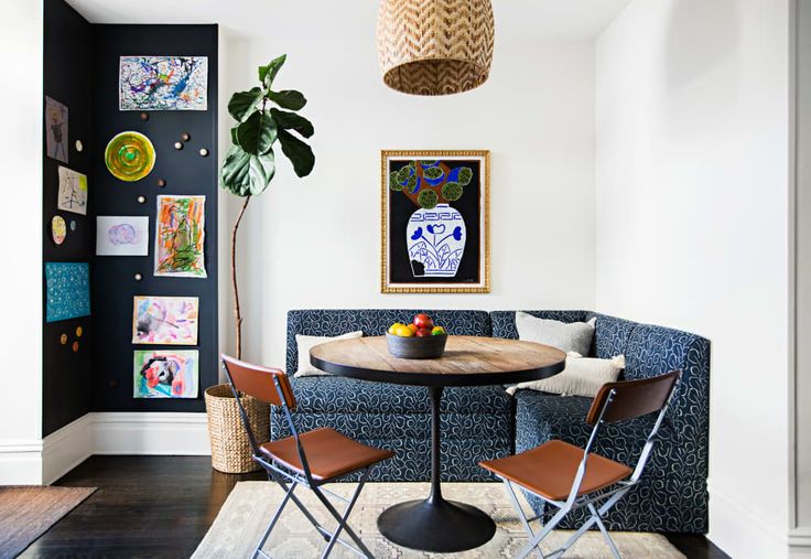 a living room filled with furniture and a round table surrounded by chairs in front of a blue couch